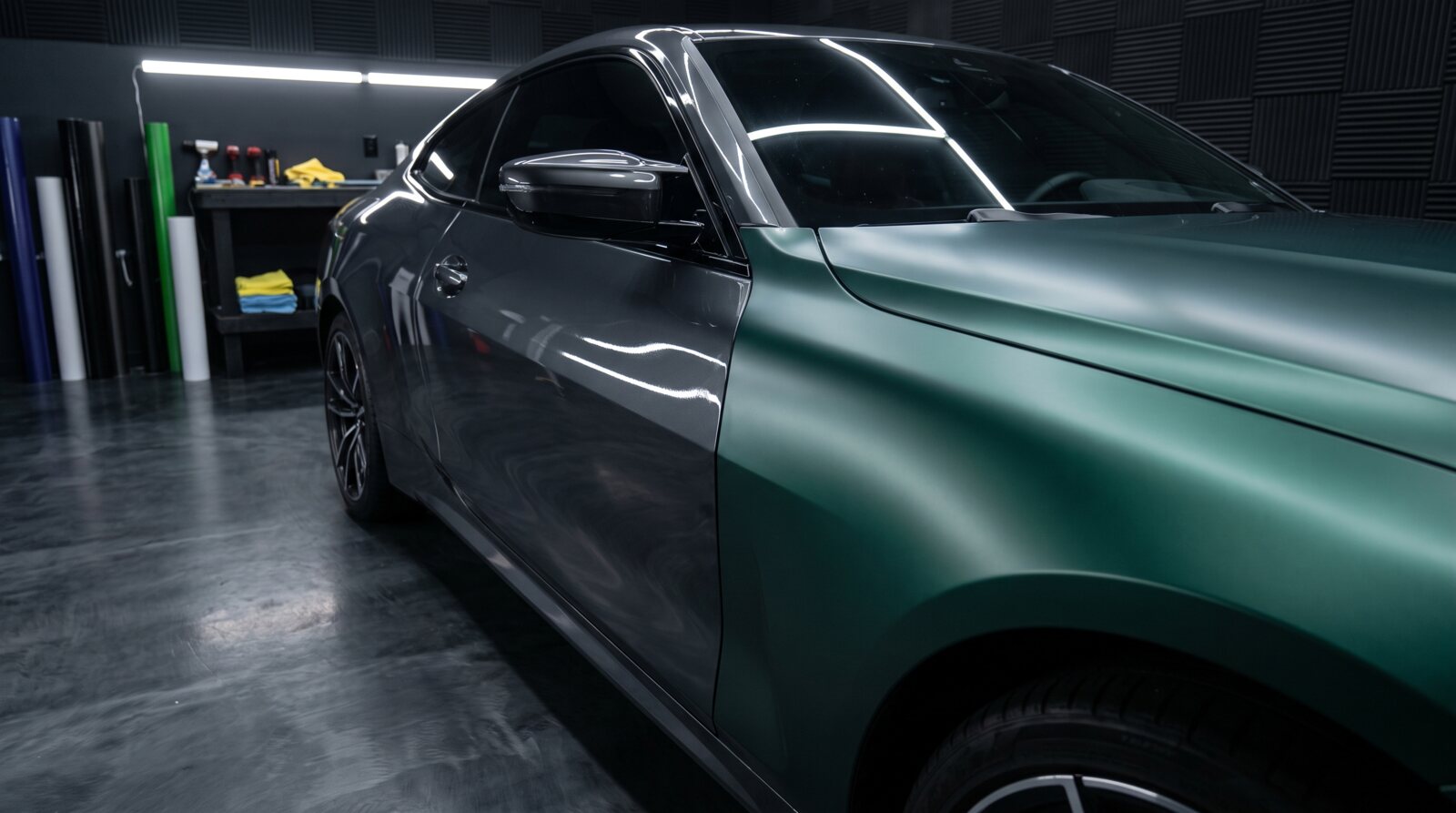 A car panel half factory gray, half satin green vinyl wrap