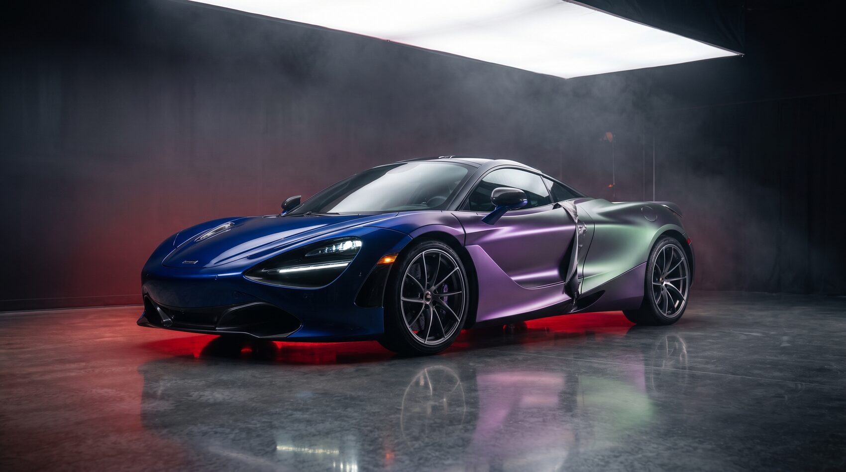 Color-shift vinyl wrap on a sports car in a dark studio